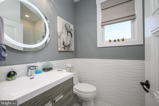 1181 Jennifer Ln, Manahawkin, NJ 08050 - bathroom featuring vanity, marble finish floor, toilet, tile walls, and a wainscoted wall