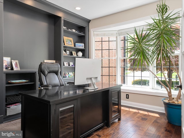 office area with dark wood-style flooring, baseboards, built in shelves, and a wealth of natural light