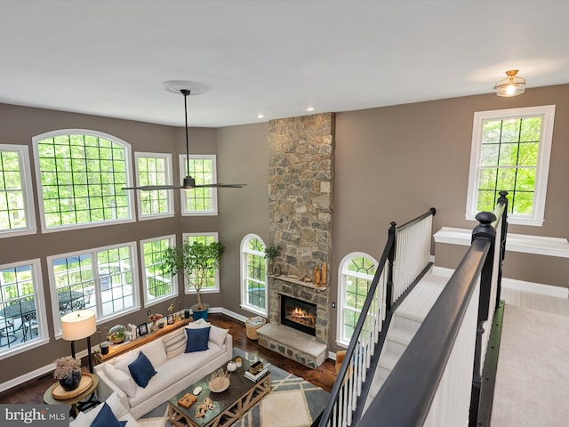 living room featuring baseboards and a stone fireplace