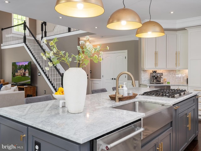 kitchen with pendant lighting, ornamental molding, light stone countertops, and stainless steel appliances