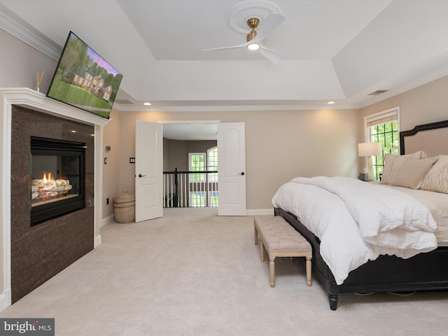 bedroom featuring recessed lighting, light colored carpet, multiple windows, and a raised ceiling