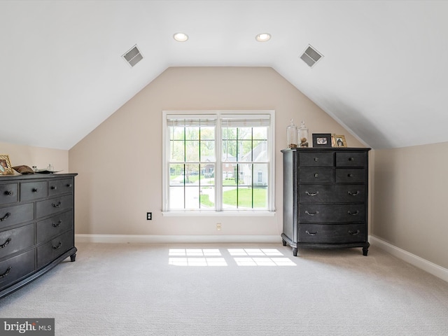 additional living space featuring visible vents, vaulted ceiling, and light colored carpet