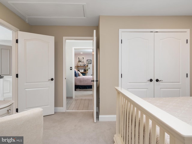 bedroom featuring baseboards, light carpet, and a closet