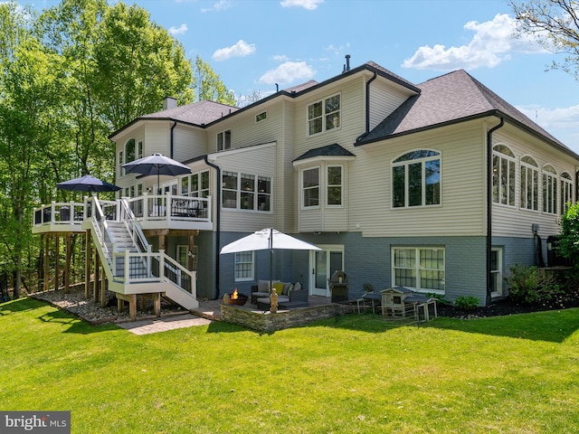 back of property with a lawn, a patio, a deck, and stairway