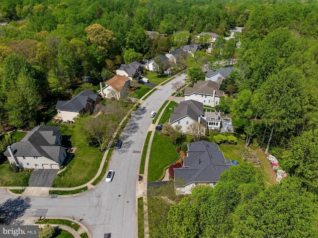 bird's eye view featuring a wooded view and a residential view