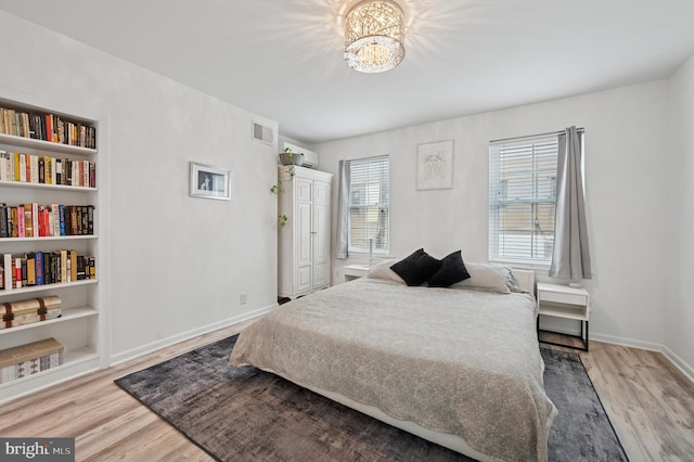 421 N 20th St, Philadelphia, PA 19130 - bedroom with a wall mounted AC, wood finished floors, baseboards, and a chandelier