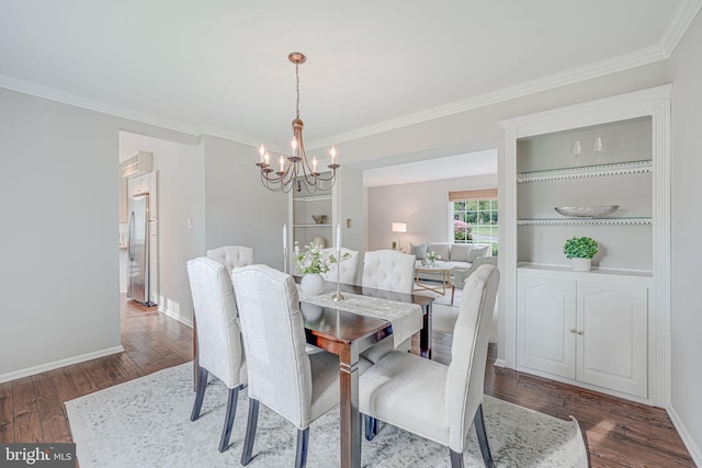 dining room with baseboards, a chandelier, ornamental molding, and wood finished floors