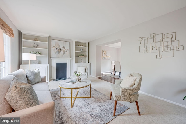carpeted living room with baseboards and a fireplace