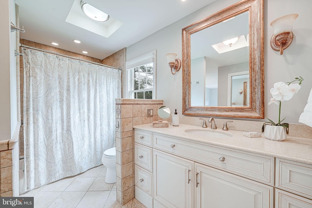 bathroom featuring vanity, toilet, a shower with shower curtain, tile patterned floors, and a skylight