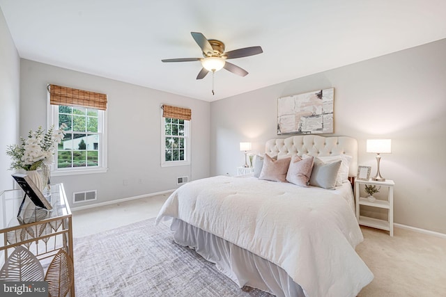 bedroom featuring light colored carpet, baseboards, ceiling fan, and visible vents
