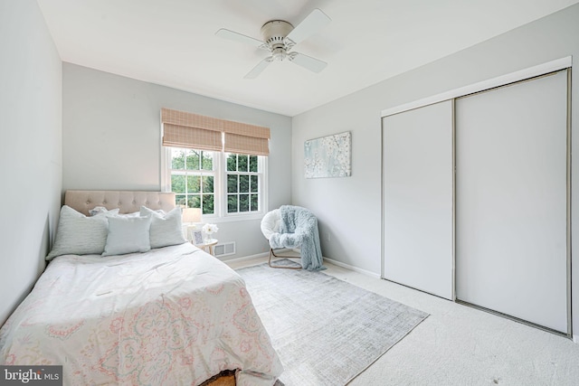 bedroom featuring carpet flooring, a ceiling fan, visible vents, and a closet