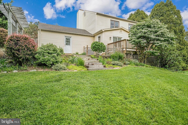 rear view of property with a yard and a deck