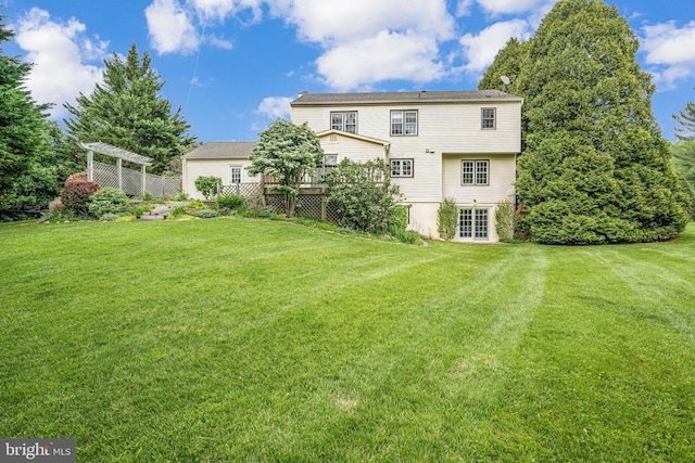 back of property with a wooden deck and a yard