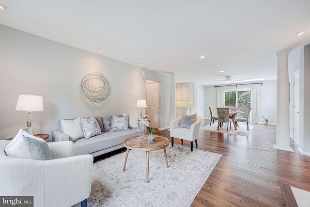 living area featuring ceiling fan, recessed lighting, baseboards, decorative columns, and wood finished floors