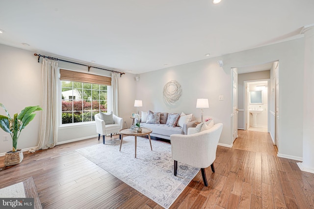 living area with recessed lighting, baseboards, and light wood-style floors