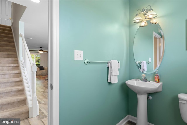 bathroom with baseboards, ceiling fan, and toilet