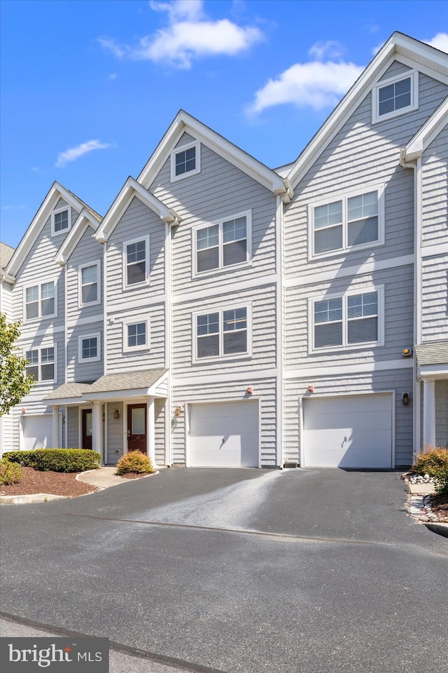view of property featuring an attached garage and driveway