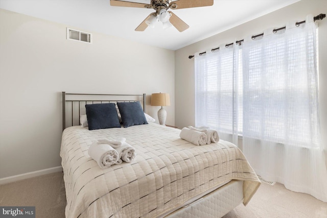 carpeted bedroom with ceiling fan, visible vents, and baseboards