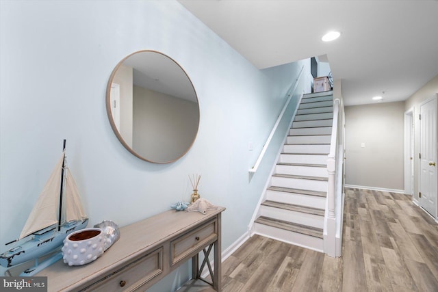 stairs with baseboards, recessed lighting, and wood finished floors