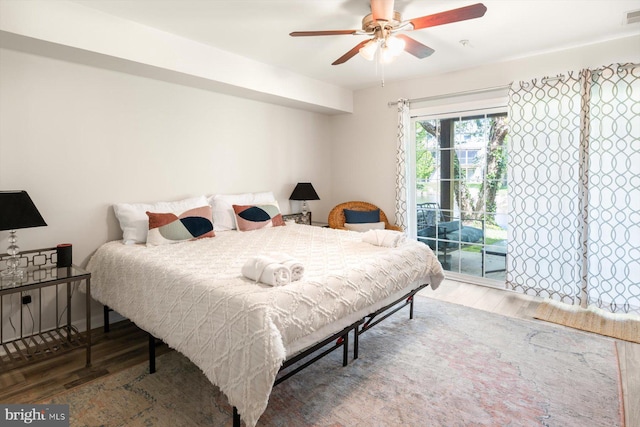 bedroom with a ceiling fan, visible vents, access to exterior, and wood finished floors