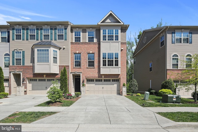 view of property featuring a garage, concrete driveway, and brick siding