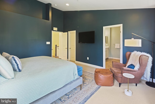 carpeted bedroom featuring baseboards, a towering ceiling, visible vents, and ensuite bathroom