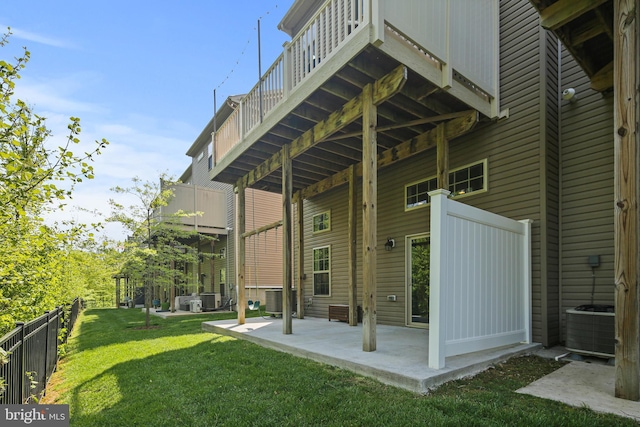 back of house featuring a lawn, central AC, fence, and a patio area
