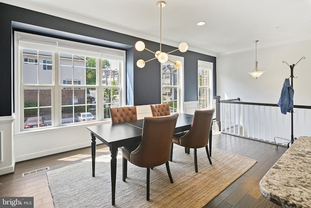 dining space with visible vents, ornamental molding, a wainscoted wall, and dark wood-style floors