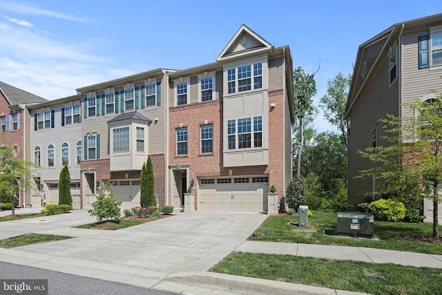 multi unit property with brick siding, driveway, and a garage