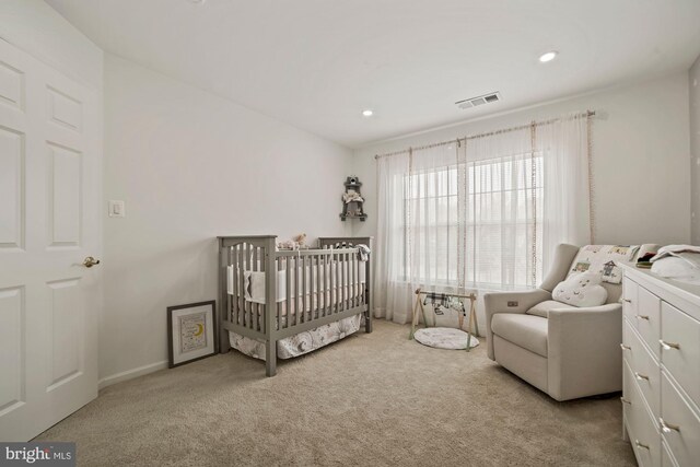 bedroom featuring a nursery area, carpet flooring, visible vents, and recessed lighting