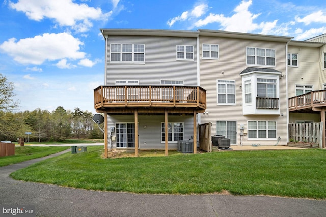back of house with central AC, a wooden deck, and a yard