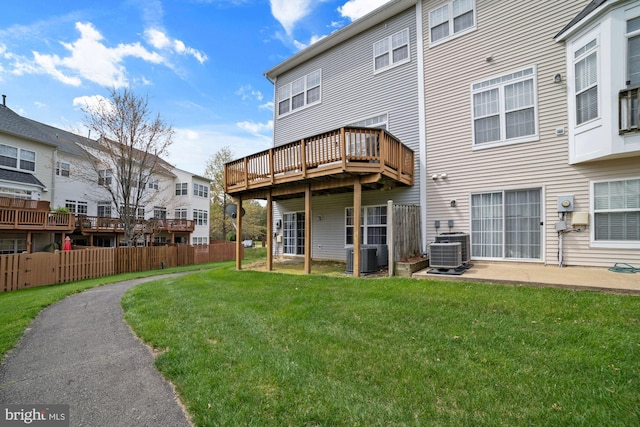 rear view of property with a residential view, cooling unit, fence, a wooden deck, and a yard