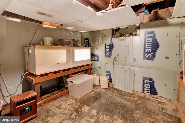 unfinished basement with visible vents and a paneled ceiling