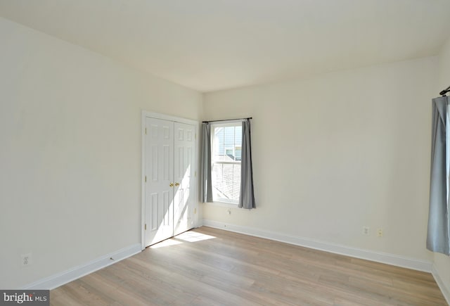 unfurnished room featuring light wood-type flooring and baseboards