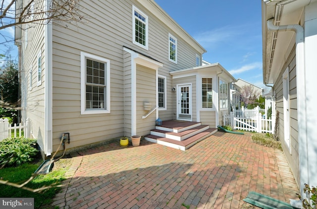 rear view of property featuring fence and a patio area