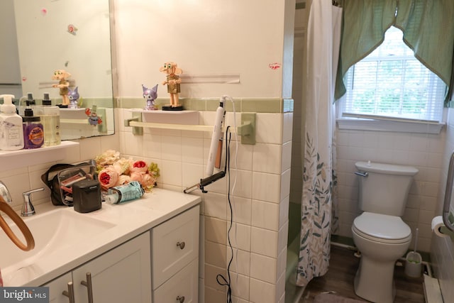 full bathroom with toilet, vanity, a wainscoted wall, and tile walls