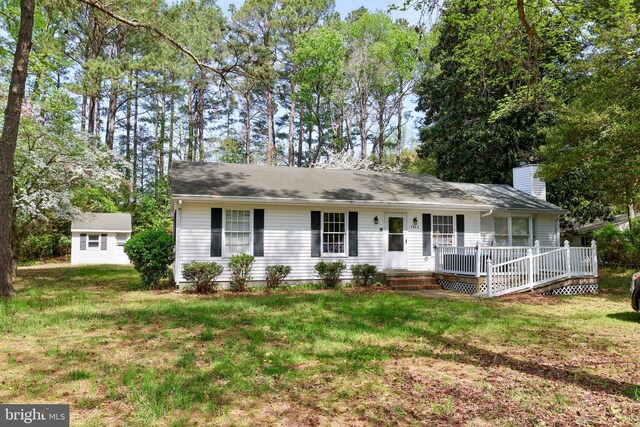 single story home with a chimney and a front lawn