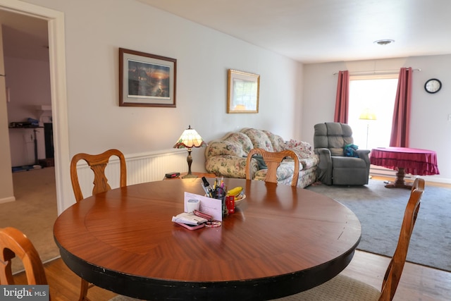 carpeted dining space featuring visible vents
