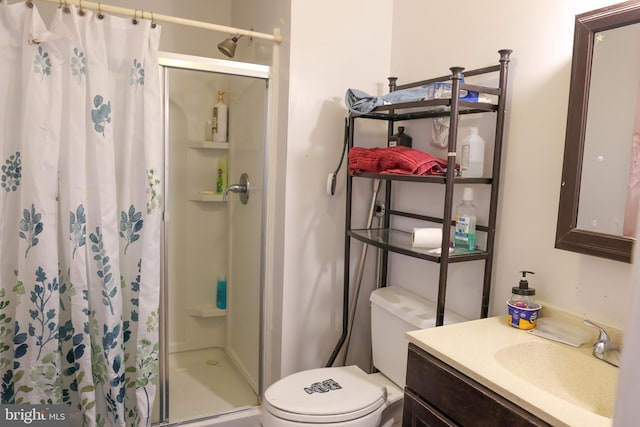 bathroom featuring a shower stall, toilet, and vanity