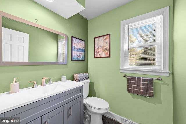 bathroom with vanity, toilet, and baseboards