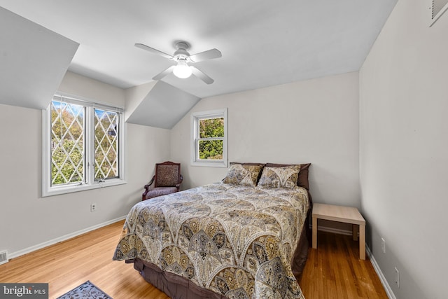 bedroom with wood finished floors, baseboards, a ceiling fan, and multiple windows