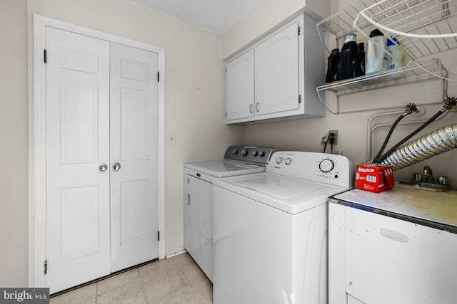 laundry area featuring cabinet space, separate washer and dryer, and light tile patterned flooring