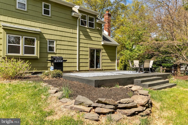 back of house with a chimney