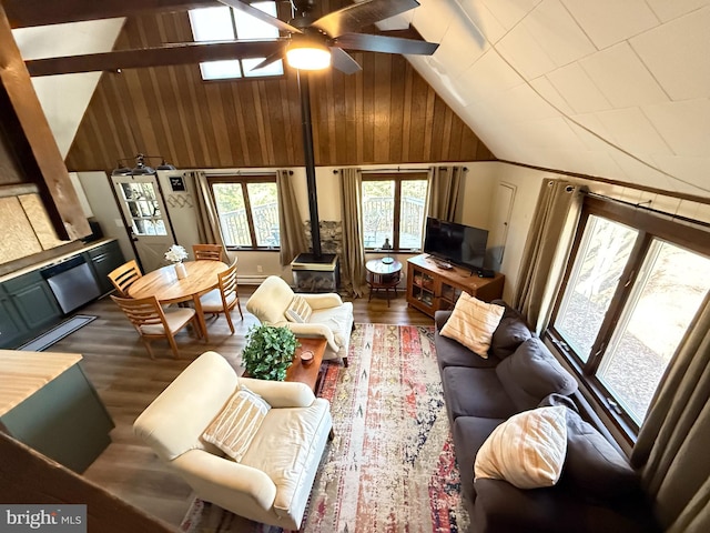 437 Orono Dr, Pocono Lake, PA 18347 - living room featuring a wood stove, ceiling fan, wooden walls, high vaulted ceiling, and dark wood finished floors