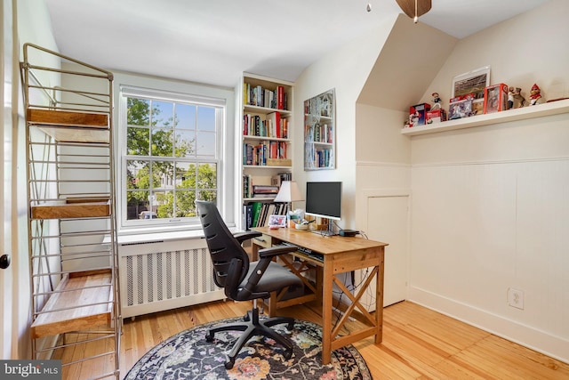 home office featuring wood finished floors and a wainscoted wall