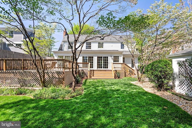 back of house with a chimney, a yard, a deck, and stairway