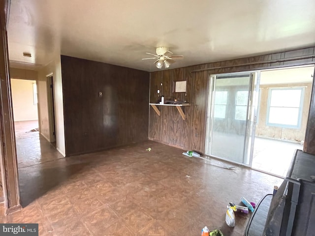5781 N Timber Ridge Rd, Berkeley Springs, WV 25411 - unfurnished living room featuring ceiling fan and wood walls