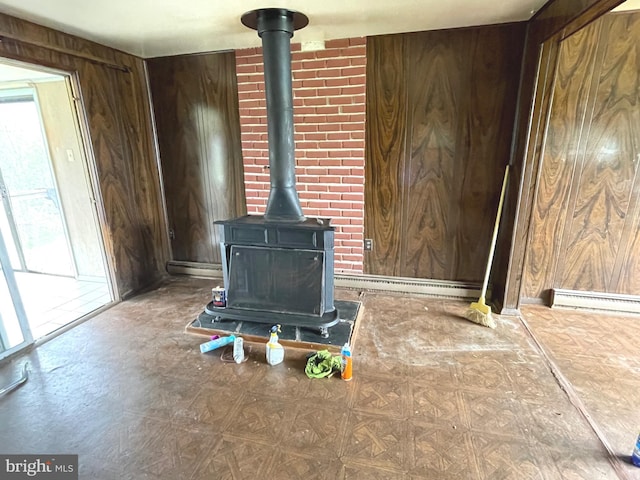 5781 N Timber Ridge Rd, Berkeley Springs, WV 25411 - interior details featuring a wood stove, a baseboard heating unit, and wooden walls