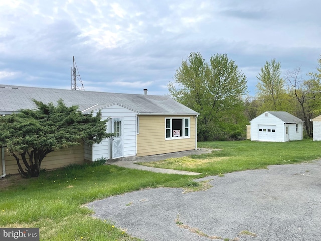 5781 N Timber Ridge Rd, Berkeley Springs, WV 25411 - view of front of house with an outdoor structure, a front yard, a garage, and a shingled roof