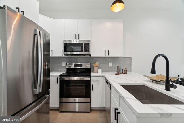 1810 Federal St Unit 1, Philadelphia, PA 19146 - kitchen with appliances with stainless steel finishes, a sink, backsplash, and light stone counters